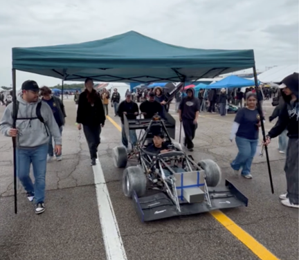 Fig. 1 UCI FSAE EV team on their way to technical inspection in the rain.