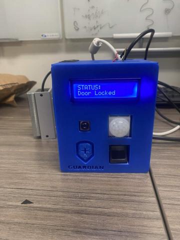 Blue 3D-printed Guardian home security system prototype with an LCD screen displaying door status, motion sensor, fingerprint reader, and connected hardware modules.